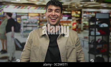 Junger hispanischer Mann, der im Supermarkt die Augen reibt; Schläfrigkeit Müdigkeit. Stockfoto