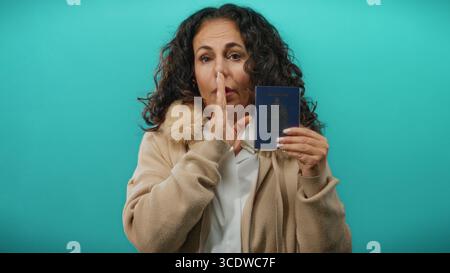 Frau mit kanadischem Pass auf blauem Hintergrund, die Merkmale und Ausdruck mittleren Alters zeigt. Stockfoto