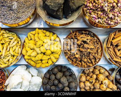 Blick von oben farbenfrohe Auswahl an verschiedenen Gewürzen und Kräutern in metallischen Schüsseln am Marktstand mit Blick von oben, Gewürzsouk, deira Creek Market, dubai VAE Stockfoto