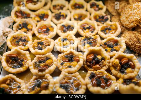 Tablett mit Gebäck mit Nüssen und Beeren. Es gibt viele von ihnen. Sie haben alle verschiedene Größen Stockfoto