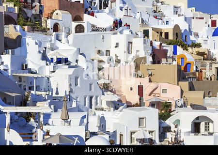 Weiße und bunt bemalte Ferienhäuser an einem steilen Hang, enge Gassen, Oia, Thira, Santorini, Kykladen, Griechenland Stockfoto