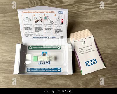 NHS-Selbsttest-Kit für Darmkrebs auf einer Holzoberfläche einschließlich Anweisungen und Screening-Testkomponenten für eine einfache und sichere Verwendung zu Hause Stockfoto