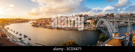 Panoramablick bei Sonnenuntergang auf das farbenfrohe Viertel Ribeira und den Fluss Douro, Porto. Historisches portugiesisches Stadtbild, Europa-Reisen, Waterfront-Charme, geschäftiges Leben Stockfoto