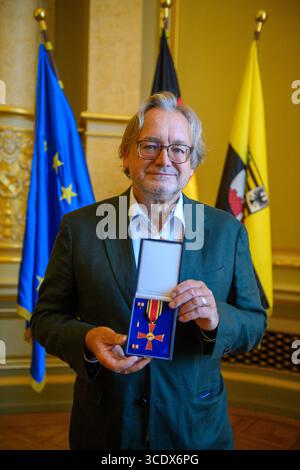 14. August 2025, Sachsen-Anhalt, Magdeburg: Der Sachsen-Anhaltische Landesarchäologe Harald Meller hält den Bundesverdienstkreuz im Ballsaal der Landeskanzlei in Händen. Die Auszeichnung wurde dem 65-Jährigen vom Ministerpräsidenten von Sachsen-Anhalt verliehen. Meller ist Direktor des Landesamtes für Denkmalpflege und Archäologe und des Landesmuseums für Vorgeschichte Halle, amtierender Leiter der Kulturstiftung Dessau-Wörlitz und Kulturbotschafter für Sachsen-Anhalt. Er prägt die Archäologie seit Jahrzehnten und rettete einst die Nebra Sky Disk vor Th Stockfoto