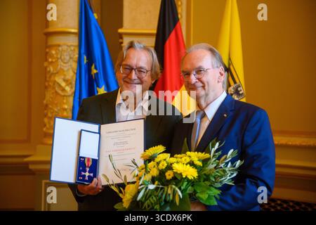 14. August 2025, Sachsen-Anhalt, Magdeburg: Reiner Haseloff (r, CDU), Ministerpräsident von Sachsen-Anhalt, überreicht im Ballsaal des Landeskanzleramtes Harald Meller, Sachsen-Anhalters Landesarchäologe, das Bundesverdienstkreuz. Meller ist Direktor des Landesamtes für Denkmalpflege und Archäologe und des Landesmuseums für Vorgeschichte Halle, amtierender Leiter der Kulturstiftung Dessau-Wörlitz und Kulturbotschafter für Sachsen-Anhalt. Er prägt die Archäologie seit Jahrzehnten und rettete einst die Nebra Sky Disk aus den Händen der Plünderer. Foto Stockfoto