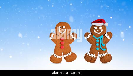 Glückliche zwei Lebkuchenkekse, Junge und Mädchen Charaktere Freunde, auf winterblauem Hintergrund mit Schnee Stockfoto
