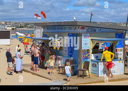 Weymouth, Dorset, Großbritannien. August 2025. Wetter in Großbritannien. Urlauber, die sich am Kiosk am Strand auf Eis warten, während sie die glühend heiße Nachmittagssonne im Badeort Weymouth in Dorset während einer Hitzewelle während der Sommerferien genießen. Bildnachweis: Graham Hunt/Alamy Live News Stockfoto