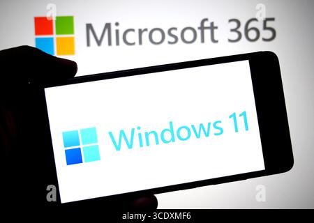 In dieser Abbildung wird ein Windows 11-Logo auf einem Smartphone mit einem Microsoft 365-Logo im Hintergrund angezeigt. Stockfoto