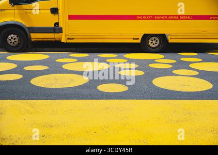 DHL-Lieferwagen parkte auf einer Straße mit gelbem Kreis Road Art Stockfoto