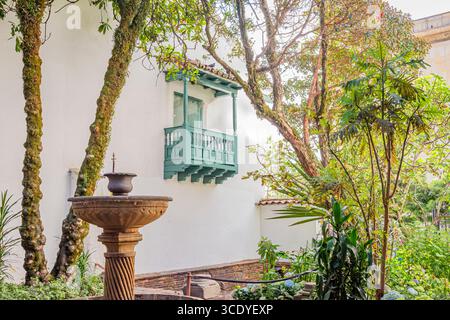 Eine malerische Szene mit einem Balkon im Kolonialstil, umgeben von üppigem Grün in Bogotá, Cundinamarca, Kolumbien. Stockfoto