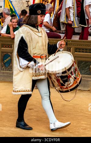 Ein Schlagzeuger von der Lupa Contrada Peforms auf der Piazza del Campo am Ende der Corteo Storico (historische Prozession), der Palio, Siena, Italien. Stockfoto
