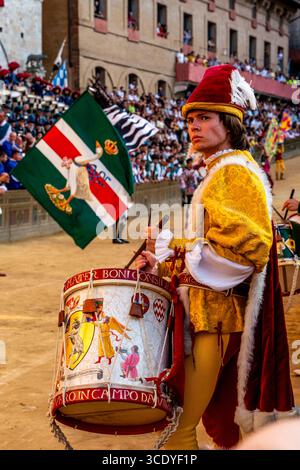 Ein Schlagzeuger der Valdimontone Contrada Peforms auf der Piazza del Campo am Ende der Corteo Storico (historische Prozession) kurz vor dem Rennen Stockfoto