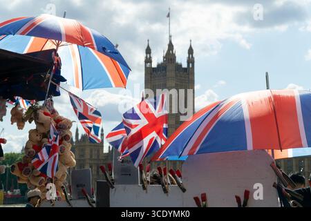 Großbritannien Wetter, 14. August 2025: Als die Temperaturen im Zentrum Londons wieder 27 Grad erreichten, verkauft ein Souvenirstand an der Westminster Bridge union Jack Flags, Regenschirme und Teddybären, mit dem Elizabeth Tower of the Houses of Parliament (der Big Ben beherbergt). Quelle: Anna Watson/Alamy Live News Stockfoto