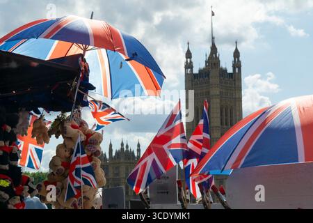 Großbritannien Wetter, 14. August 2025: Als die Temperaturen im Zentrum Londons wieder 27 Grad erreichten, verkauft ein Souvenirstand an der Westminster Bridge union Jack Flags, Regenschirme und Teddybären, mit dem Elizabeth Tower of the Houses of Parliament (der Big Ben beherbergt). Quelle: Anna Watson/Alamy Live News Stockfoto