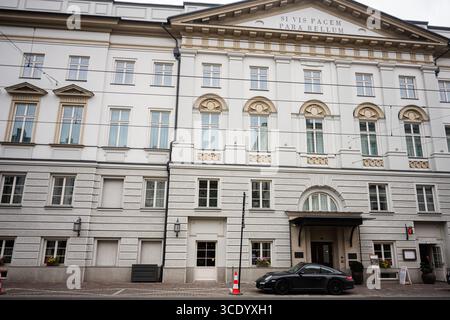 Krakau, Polen - 08. Juli 2025: Schöne architektonische Fassade eines historischen Gebäudes mit einem modernen Auto in Stradomska, Krakau. SI Vis pacem, Para bell Stockfoto