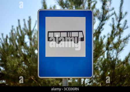Blaues quadratisches Straßenschild mit einem Bussymbol, das den Standort einer offiziellen Bushaltestelle kennzeichnet. Dient zur Führung von Fahrern und Fahrgästen, um öffentliche Verkehrsmittel zu gewährleisten Stockfoto
