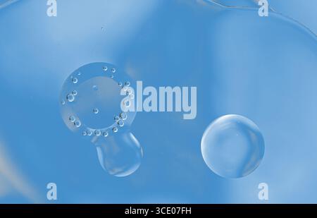Abstrakter blauer Hintergrund mit Öl auf Wasseroberfläche. Öltropfen im Wasser abstrakte psychedelische, abstrakte Designs und Formen. Stockfoto