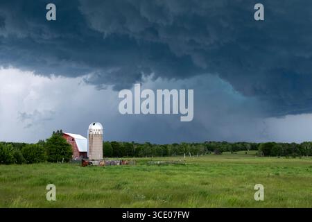 Dramatische schwere Gewitter über einer Scheune und einem Silo im ländlichen Cass County, Minnesota Stockfoto