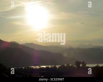 Wenn der Abend untergeht, wirft die Sonne goldene Strahlen über den Skadar-See, beleuchtet die umliegenden Berge und schafft eine friedliche, ruhige Atmosphäre Stockfoto
