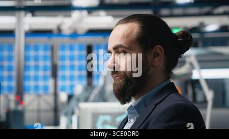 Professioneller Berater, der die Qualität der Solarenergie in einer Fabrik überprüft, Datenberichte und Einblicke für nahtlose Produktionslinien und nachhaltige Solarenergie überprüft. Photovoltaik-Industrie. Kamera B.. Stockfoto
