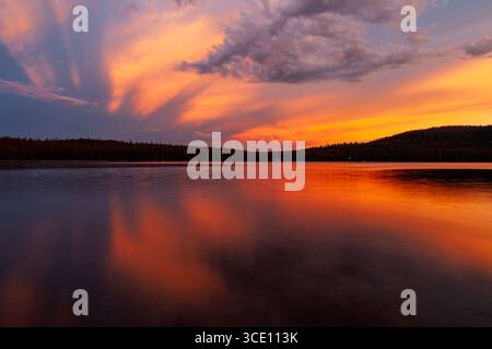 Das letzte Licht des Tages erhellt die aufragenden Wolken über dem Medicine Lake im Norden Kaliforniens Stockfoto
