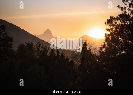 Golden Horizon hinter den Berggipfeln in Itaipava, Brasilien Stockfoto
