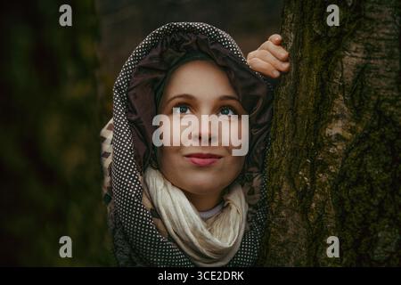 Frau im Kapuzenkostüm mit halloween Dekor im dunklen Wald Stockfoto