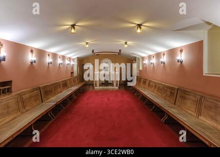 Jugendherberge Im Kloster Montserrat Innenkapelle Mit Rotem Teppich Und Holzbänken. Religiöse Architektur, Klösterliche Unterkunft, Heiliger Raum Stockfoto