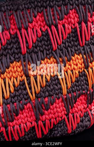 Damenhandtasche braun handgestrickt mit orange-roten Geweben und langem Griff. Handgefertigt Stockfoto