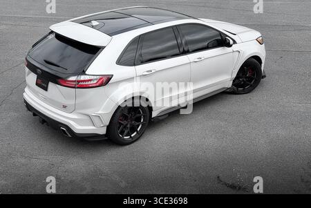 White Edge ST auf einem großen Parkplatz. Dreiviertel-Rückansicht des sportlichen Ford SUV auf großer grauer Asphaltoberfläche – Luftaufnahme. Stockfoto