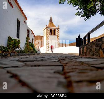 Wanderer mit Blick auf den maurischen Glockenturm der alten Kirche im Dorf Betancuria, Fuerteventura, Kanarischen Inseln, Spanien Stockfoto