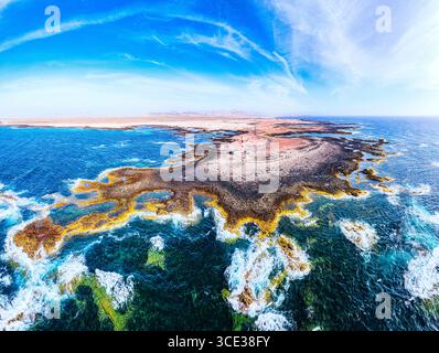 Luftaufnahme der Wellen, die an der Küste in der Nähe des Leuchtturms El Toston, El Cotillo, Fuerteventura, Kanarischen Inseln, Spanien abstürzen Stockfoto