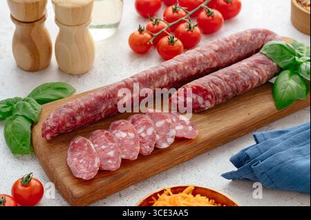 Geräucherte Wurst auf Holzbrett und Tomaten Stockfoto