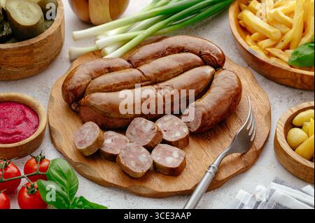 Geräucherte Wurst mit Schmalz mit frischem Gemüse und Pommes frites Stockfoto