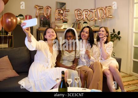 Gruppe junger multiethnischer Frauen, die Selfie bei der Brautduschparty nehmen Stockfoto