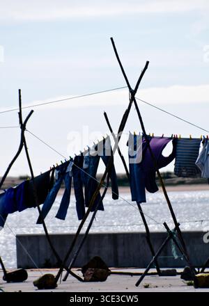 Kleidung hängt an einer Wäscheleine, trocknet in der Sonne. Stockfoto