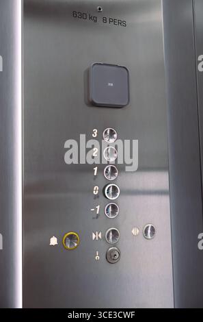 Nahaufnahme der Schaltflächen des Elevators mit den Stockwerknummern und Anzeigen. Eine detaillierte Ansicht des Bedienfelds des Fahrstuhls mit Metalltasten, Boden Stockfoto