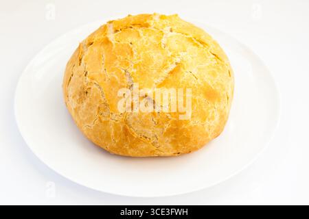 Rundes weißes Brot auf einer weißen Platte mit weißem Hintergrund. Stockfoto