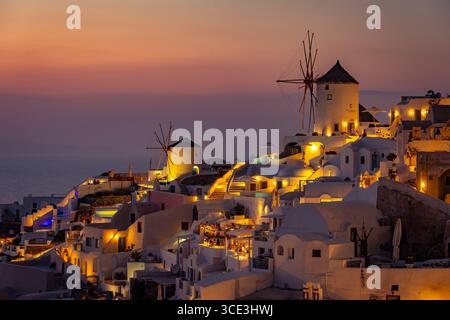 Santorini Oia Windmühlen beleuchtet bei Sonnenuntergang, Griechenland Stockfoto
