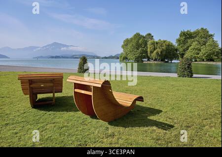 Zwei Holzliegen auf einer Wiese mit Blick auf den Zugersee, Villette, Park, Cham, Kanton Zug, Schweiz Stockfoto