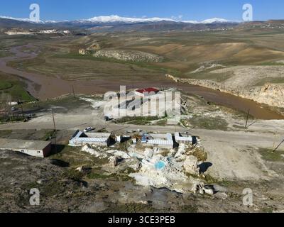 Hügelige Landschaft mit einem Fluss und dunklen Hügeln, Gebäude am Ufer, Blick aus der Vogelperspektive, Thermalquellen, Diyadin, Murat River, Provinz Agri, AGrIJ, Ost Stockfoto
