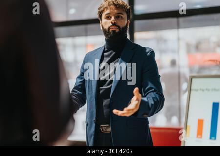 Professioneller Mann, der eine Präsentation während eines Geschäftstreffens in einem Büro hält Stockfoto
