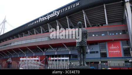 CARDIFF, Großbritannien - 8. AUGUST 2025 - die Statue von Sir Tasker Watkins steht stolz vor dem beeindruckenden Principality Stadium, einem prominenten Wahrzeichen in Cardif Stockfoto