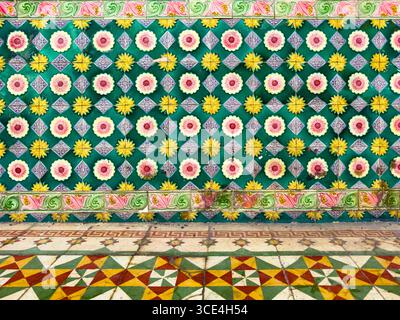 Farbenfrohe Fliesenboden- und Wandfliesen mit lebendigen geometrischen Mustern und Blumenmotiven in traditionellem Design Stockfoto