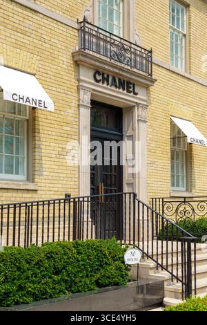 Das Chanel-Schaufenster in Yorkville verfügt über eine schwarze Tür, die von Steinsäulen, schmiedeeisernen Geländern und weißen Markisen an einer gelben Ziegelfassade eingerahmt ist. Stockfoto