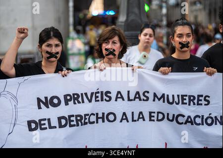 Madrid, Spanien. August 2025. Frauen mit Klebeband im Mund protestieren schweigend gegen den Verlust der Grundrechte für Frauen und Mädchen in Afghanistan. Der 15. August ist vier Jahre her, seit die Taliban in Afghanistan an die Macht zurückgekehrt sind. Quelle: Marcos del Mazo/Alamy Live News Stockfoto