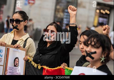 Madrid, Spanien. August 2025. Frauen mit Klebeband im Mund protestieren schweigend gegen den Verlust der Grundrechte für Frauen und Mädchen in Afghanistan. Der 15. August ist vier Jahre her, seit die Taliban in Afghanistan an die Macht zurückgekehrt sind. Quelle: Marcos del Mazo/Alamy Live News Stockfoto
