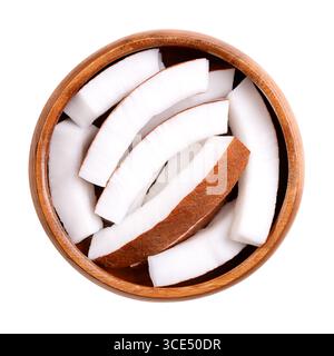 Rohes Kokosfleisch, in einer Holzschale. Deckendes weißes Fleisch einer frischen und jungen Kokosnuss, in Streifen geschnitten und verzehrfertig. Stockfoto