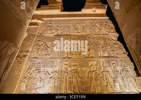 Ein beeindruckender Blick auf die atemberaubenden Hieroglyphen und Schnitzereien an den Innenwänden des Tempels von KOM Ombo. Die antike Kunst wird am Nig brillant beleuchtet Stockfoto