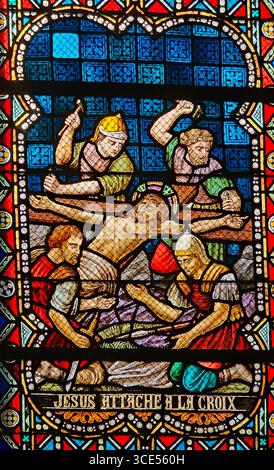 Rochefort, Belgien - 23. Juli 2025: Buntglasfenster, in dem Jesus an das Kreuz genagelt wird Stockfoto
